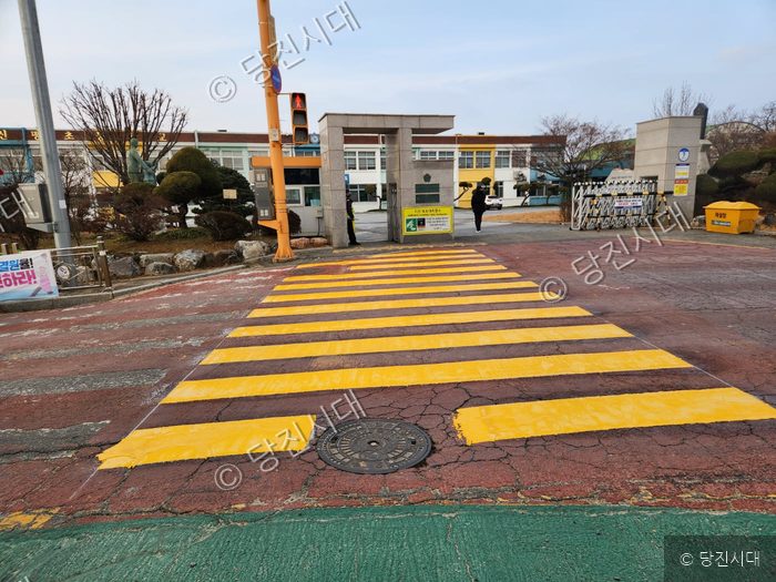 대한건설이 시공한 노란색 횡단보도가 학교 앞에 그려져 있다.