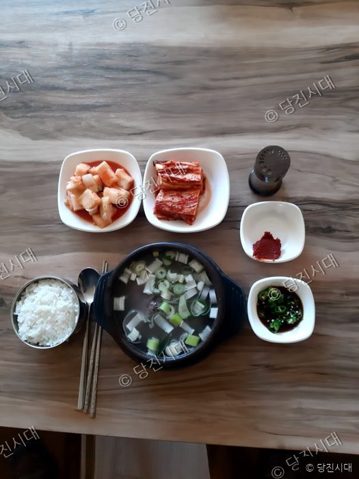 식당 테이블에 국밥과 반찬들이 놓여 있다.