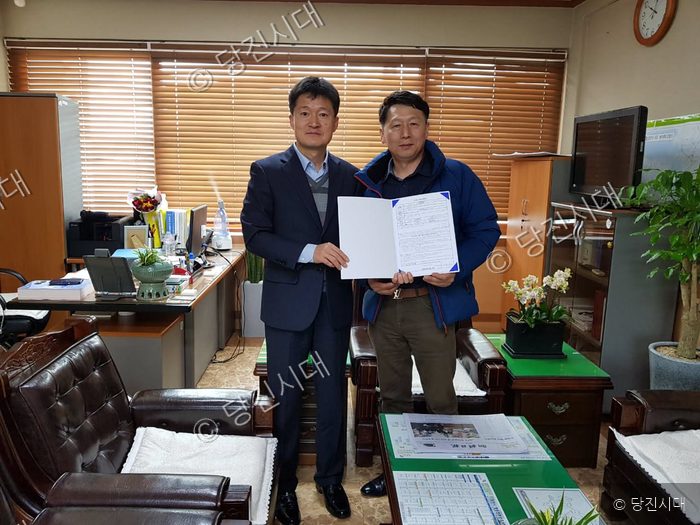 심인섭 씨 등이 사무실에서 문서 증서를 함께 들어 보이고 있다.