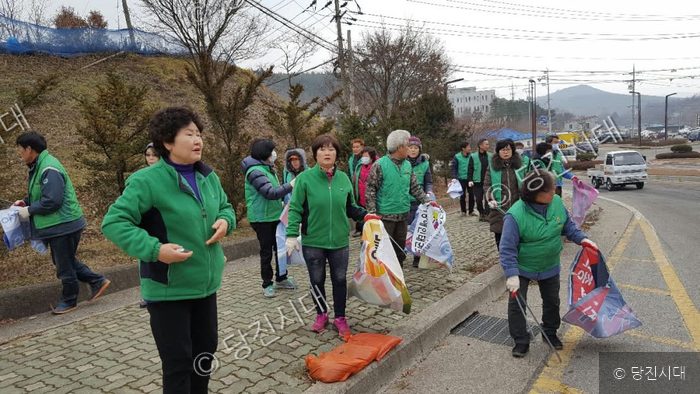 마을 주민들이 길가에서 새마을운동 환경정화 활동을 하고 있다.