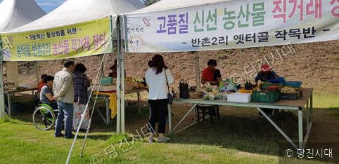 주민들이 송악읍 반촌2리 농산물 직거래 장터에서 물건을 고르고 있다.