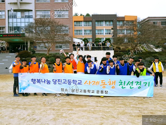 당진고등학교 학생들이 운동장에서 사제동행 친선경기를 기념하고 있다.