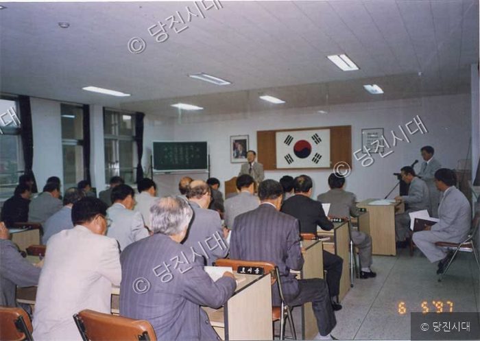 실내 강당에서 참석자들이 강연을 경청하고 있다.