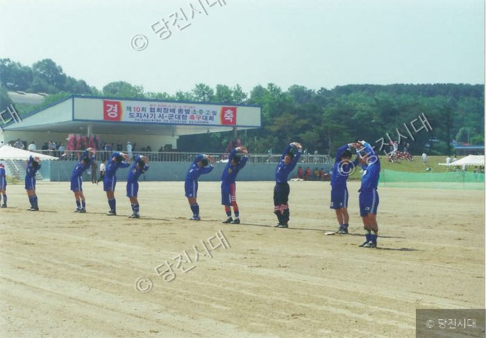 축구 선수들이 운동장에서 스트레칭을 하고 있다.