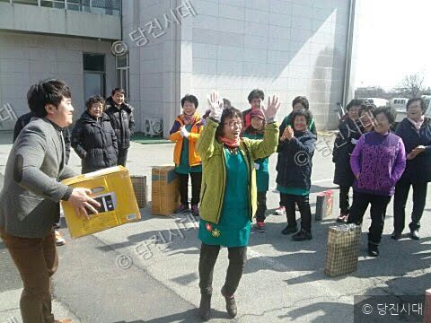 지역 주민들이 선물 상자를 들고 기념 촬영을 하고 있다.