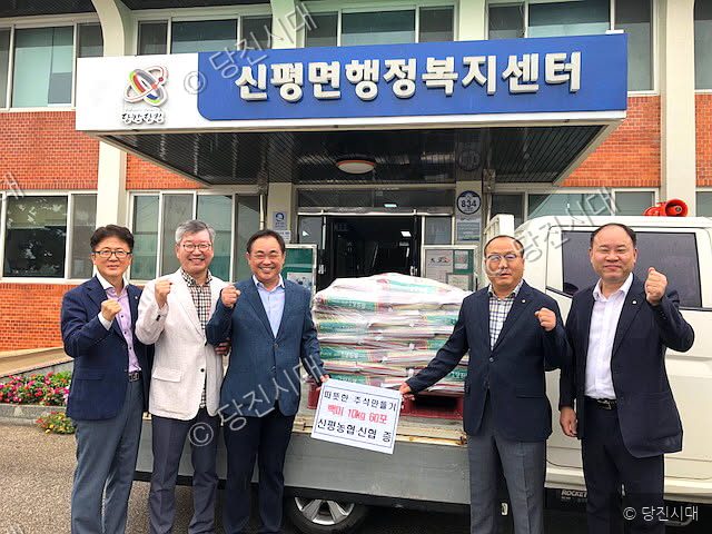 관계자들이 신평면행정복지센터 앞에서 추석 명절맞이 물품을 기증하고 있다.
