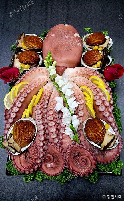 정갈하게 차려진 문어와 해산물 요리 한 상이 놓여 있다.