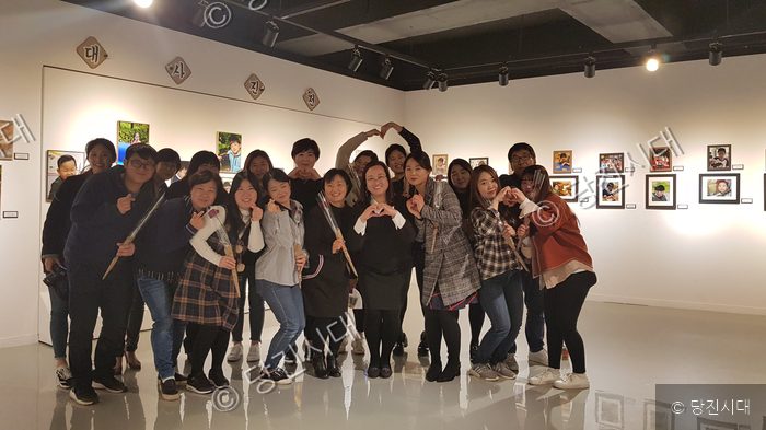 하람어린이집 관계자들이 사진전 전시장 기념촬영에서 환하게 웃고 있다.