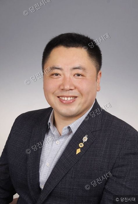정장 차림의 홍성호 예비후보가 환하게 미소 지으며 정면을 응시하고 있다.