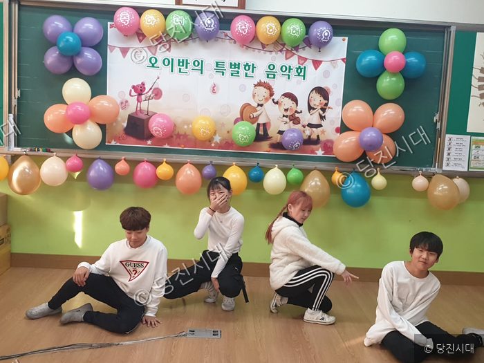 유곡초 학생들이 동아리 발표회 무대 앞에서 포즈를 취하고 있다.
