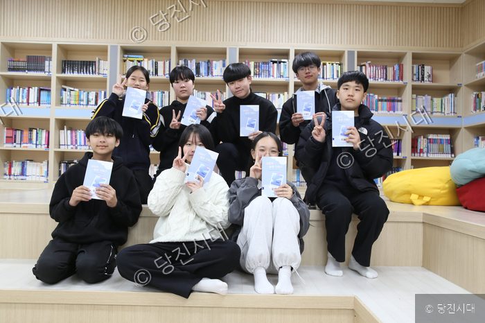 여덟 명의 청소년들이 '대호지 필름 카메라' 책을 들고 포즈를 취하고 있다.