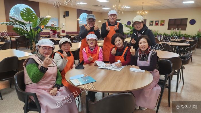 지역 봉사로 표창을 받은 어르신들이 모여 환하게 미소 짓고 있다.