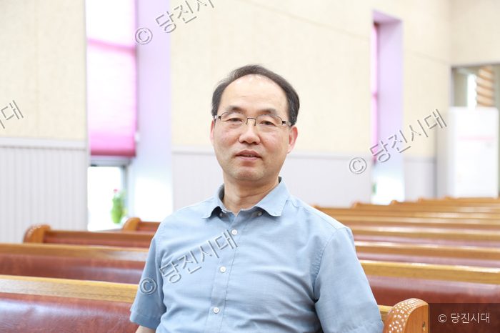 이명우 감리사가 예배당에 앉아 카메라를 응시하고 있다.