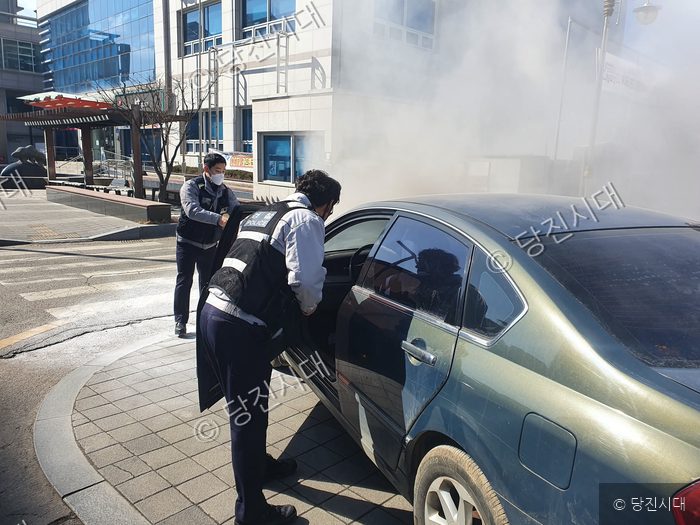 경찰관들이 화재가 발생한 차량에서 운전자를 구조하고 있다.