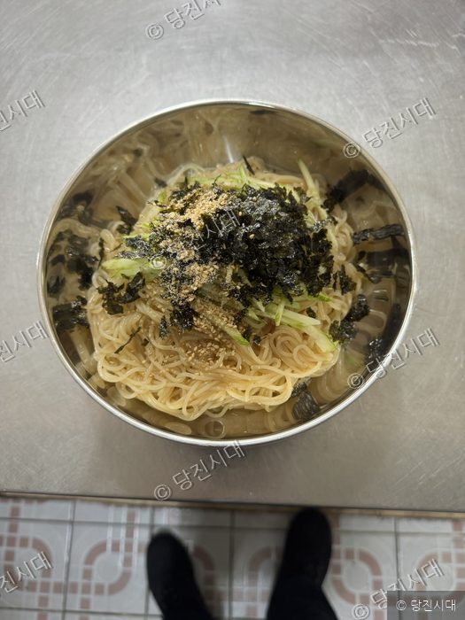 스테인리스 그릇에 담긴 간장비빔국수와 고명들의 모습.