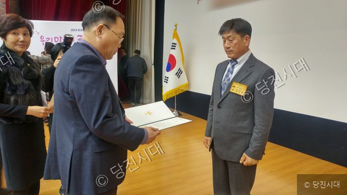한 남성이 시상식에서 상장을 받고 있다.