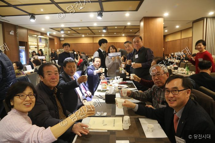 향우회 회원들이 식사 자리에서 밝은 표정으로 건배를 하고 있다.