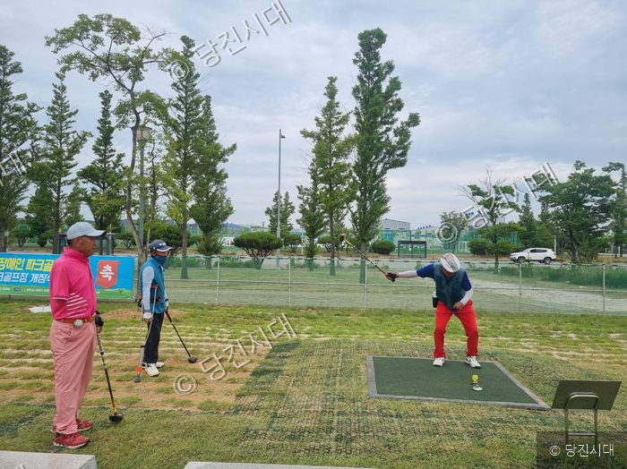 참가자가 장애인 파크골프대회 경기장에서 티샷을 준비하고 있다.