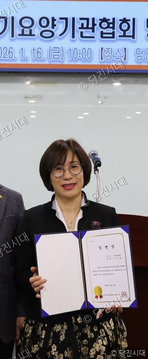 이옥화 지회장이 임명장을 들고 미소를 짓고 있다.