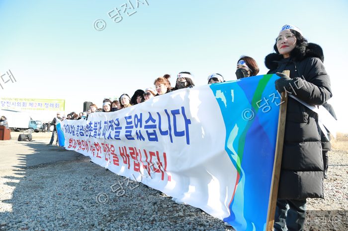 여성들이 현수막을 들고 서서 시위를 벌이고 있다