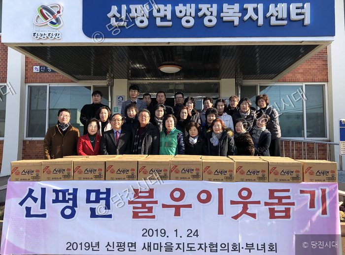 신평면 행정복지센터 앞에서 단체 관계자들이 불우이웃돕기 물품을 기부하고 기념 촬영을 하고 있다.