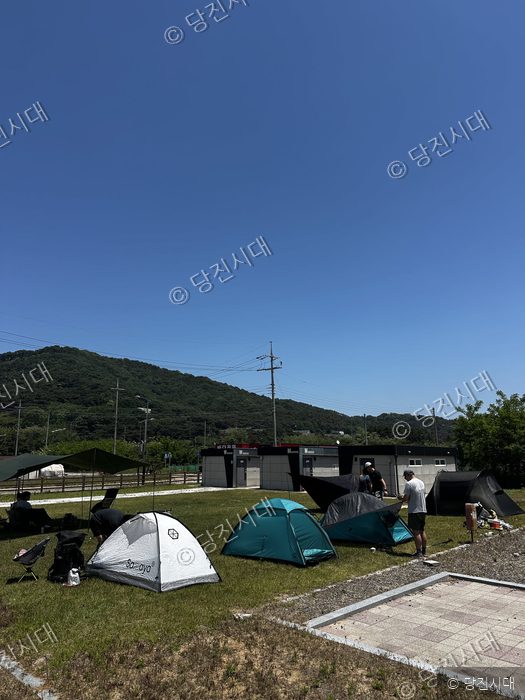 여행객들이 난지도 캠핑장에서 텐트를 치고 휴식을 취하고 있다.