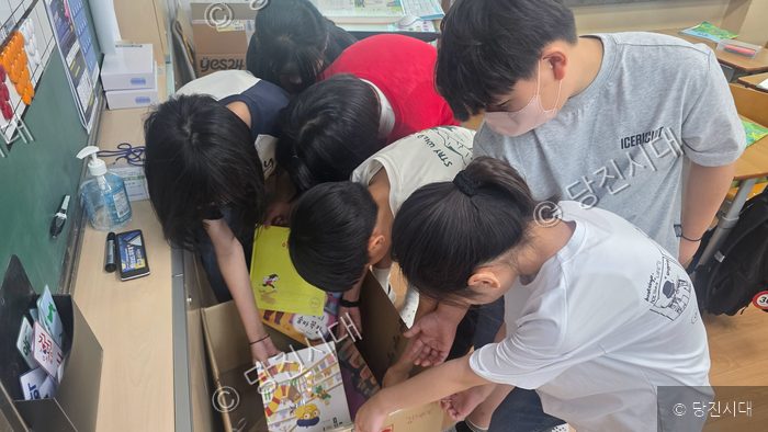 당진초등학교 학생들이 교실에 전달된 도서 상자를 함께 살펴보고 있다.