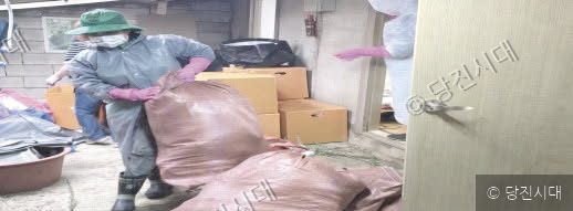 새마을운동 회원들이 방역복을 입고 봉사활동을 하고 있다.