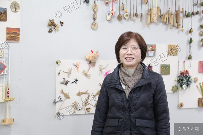 숲인들 두드림 강정숙 대표가 작품이 전시된 공간에서 포즈를 취하고 있다.