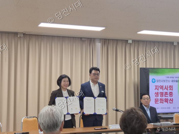 당진시보건소와 새마을 관계자들이 생명존중안심마을 협약서를 들어 보이고 있다.