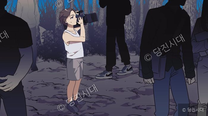 데니스 환이 과거를 떠올리며 카메라를 들고 어딘가를 응시하고 있다.