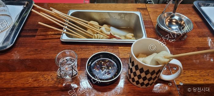 수청동 우마이오뎅바에서 어묵탕과 술 한 잔이 차려져 있다.