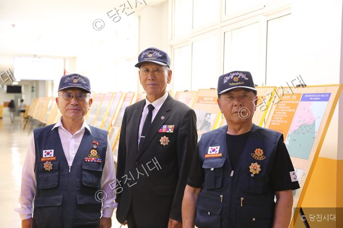 당진정보고에서 열린 한국전쟁 사진전에서 전우회 회원들이 포즈를 취하고 있다.