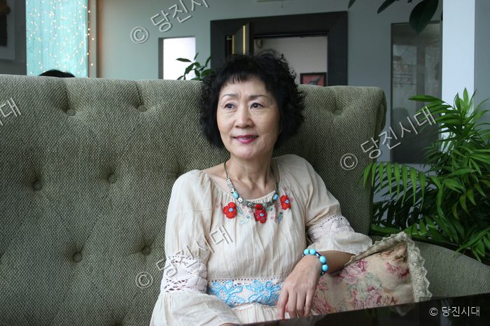 하우림 시인이 실내 소파에 앉아 어딘가를 바라보고 있다.