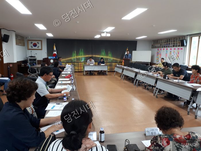 사람들이 회의실에 모여 회의를 진행하고 있다.