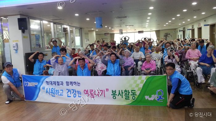 자원봉사자들이 어르신들과 함께 기념사진을 찍고 있다.
