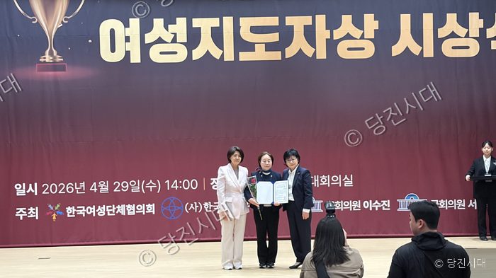 여성지도자상 시상식에서 수상자가 상장을 받고 기념 촬영을 하고 있다.