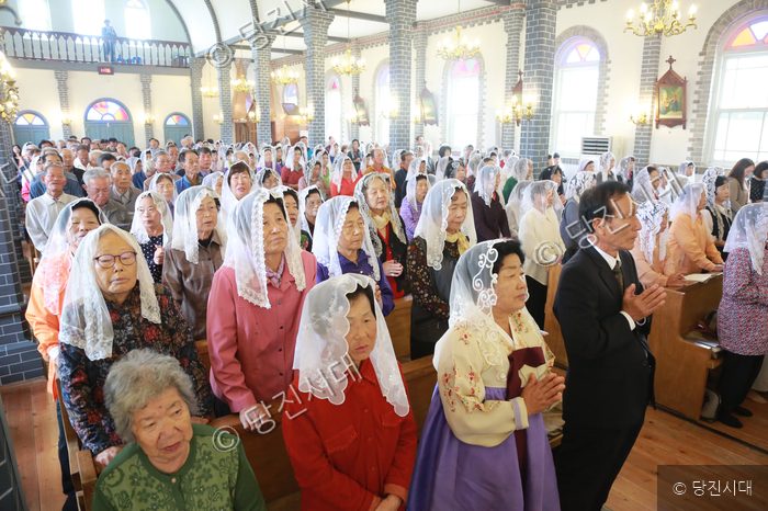 합덕성당 90주년 기념 미사에 참석한 신도들이 기도를 드리고 있다.