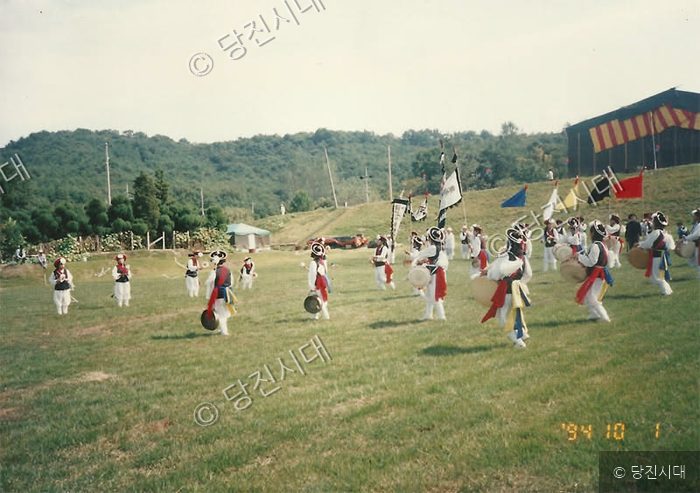 야외 잔디밭에서 풍물패가 전통 농악 놀이를 공연하고 있다.