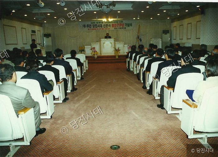 사람들이 강당에 모여 창간 7주년 기념식을 진행하고 있다.
