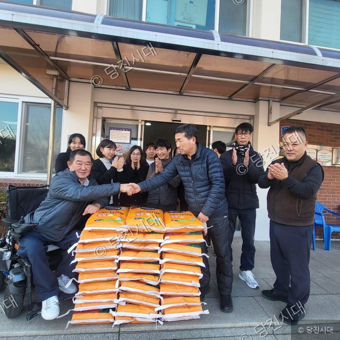 연말을 맞아 휠체어를 탄 시민에게 쌀 30포를 전달하고 있다.