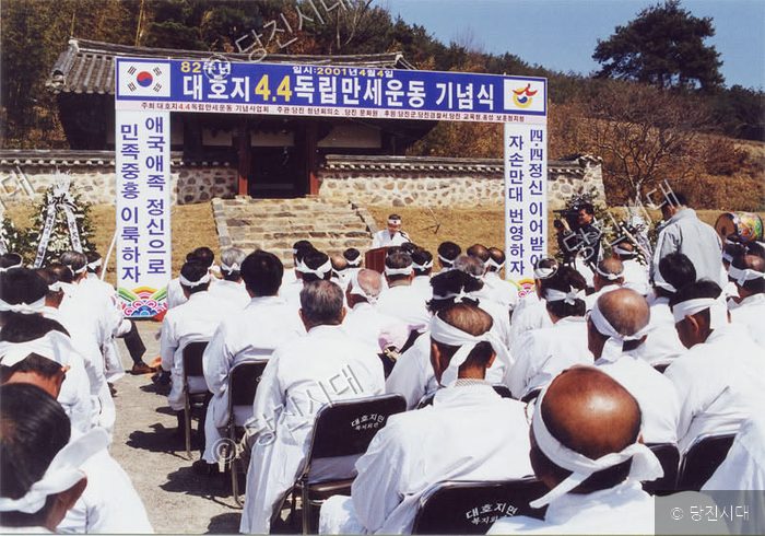 사람들이 대호지 4.4 독립만세운동 기념식에 참석해 앉아 있다.