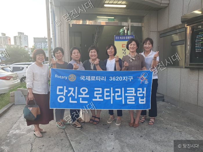 당진온로타리클럽 회원들이 현수막을 들고 기념 촬영을 하고 있다.