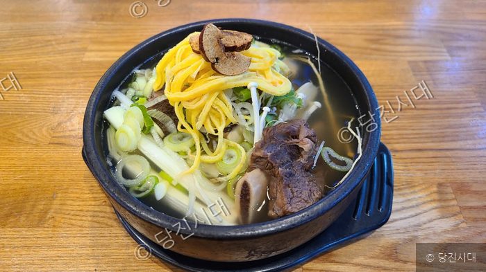 뚝배기에 담긴 갈비탕이 먹음직스럽게 놓여 있다.
