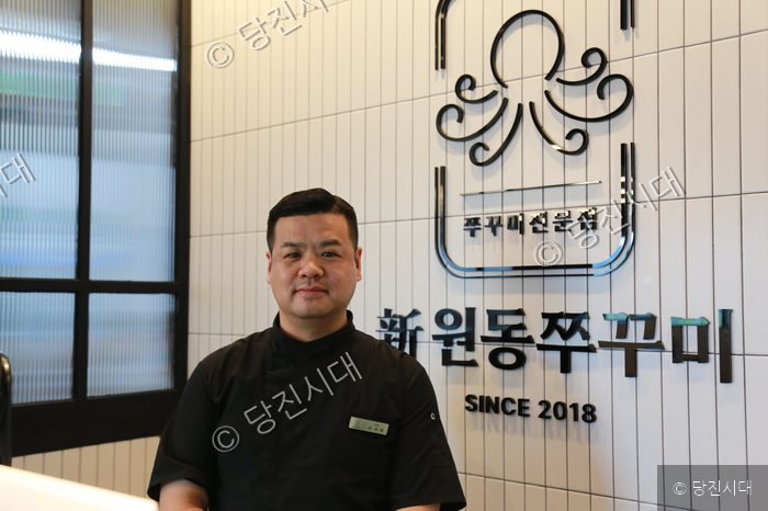 식당 대표가 쭈꾸미 전문점 매장에서 포즈를 취하고 있다.
