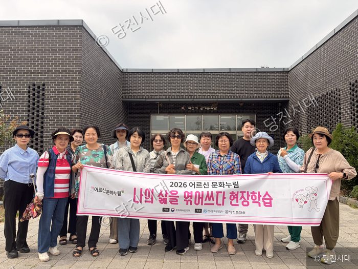 당진문화원 신현만 원장 등이 현장학습 기념 현수막을 들고 포즈를 취하고 있다.