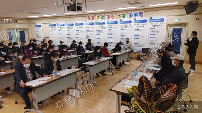 주민들이 회의실에 모여 회의를 진행하고 있다.
