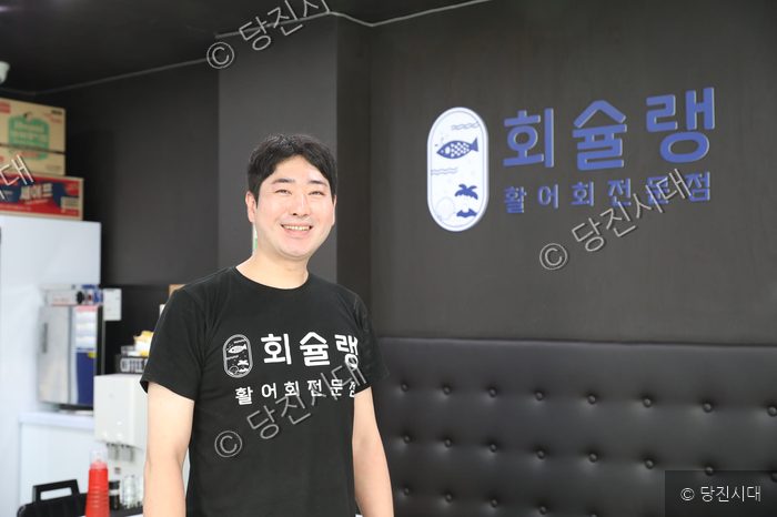 당진 읍내동에 위치한 회슐랭의 이재준 대표가 매장 내부에서 환하게 미소 짓고 있다.