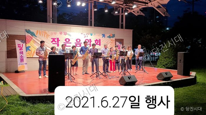 필색소폰클럽 회원들이 야외 무대에서 작은 음악회를 열고 있다.