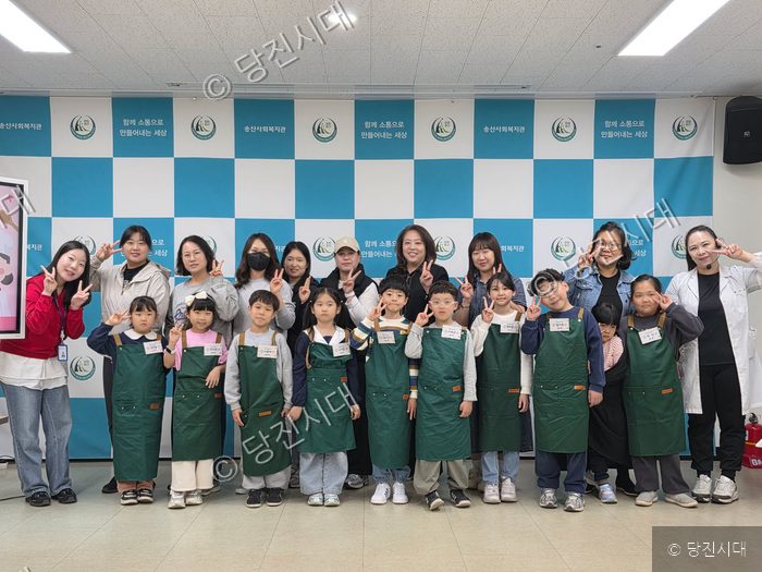 송산사회복지관에서 아동 대상 창의요리프로그램 참정경윤 관장 등이 기념 촬영을 하고 있다.